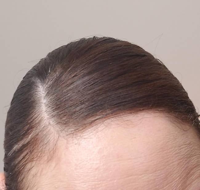 close up of person with hair slicked back with wax stick