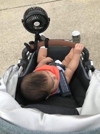 a reviewer's black fan attached to their stroller