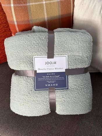 A sage green JOOJA Boucle Fleece Blanket