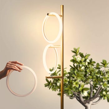 Model placing one of the light rings on a branch of the floorlamp