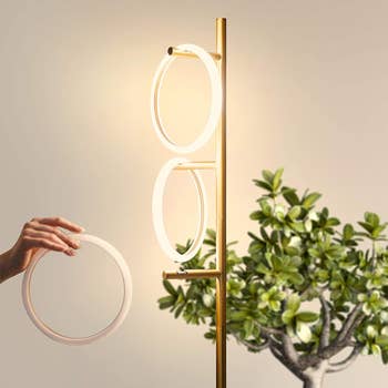 Model placing one of the light rings on a branch of the floorlamp 