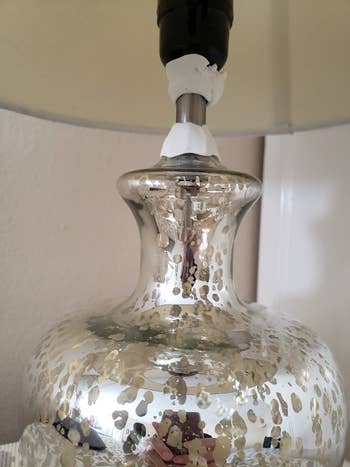 reviewer image of the white moldable glue used on a lamp to stop the shade from wobbling