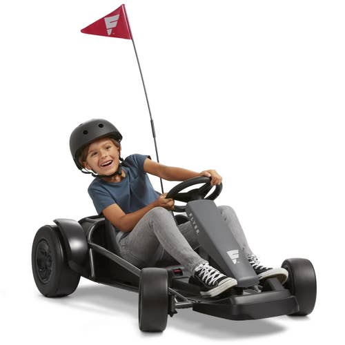 Child model driving black and gray go-kart with red triangle flag