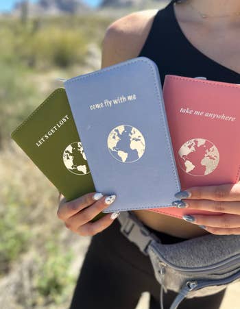 mode holding three travel wallets with phrases 