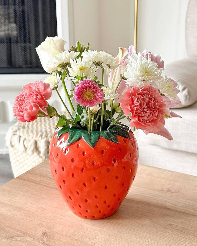 strawberry shaped vase with flowers inside