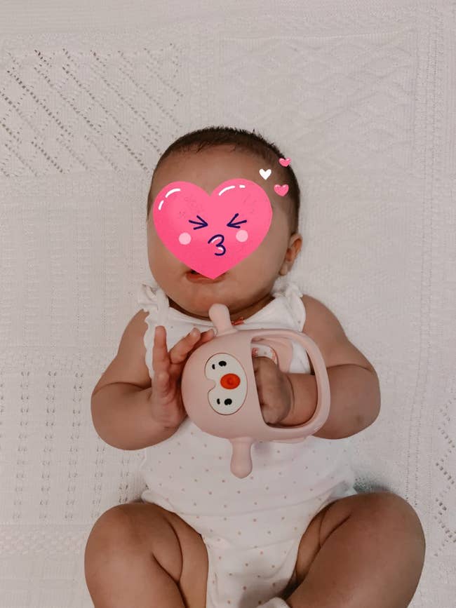 reviewer's baby with teething toy on their hand