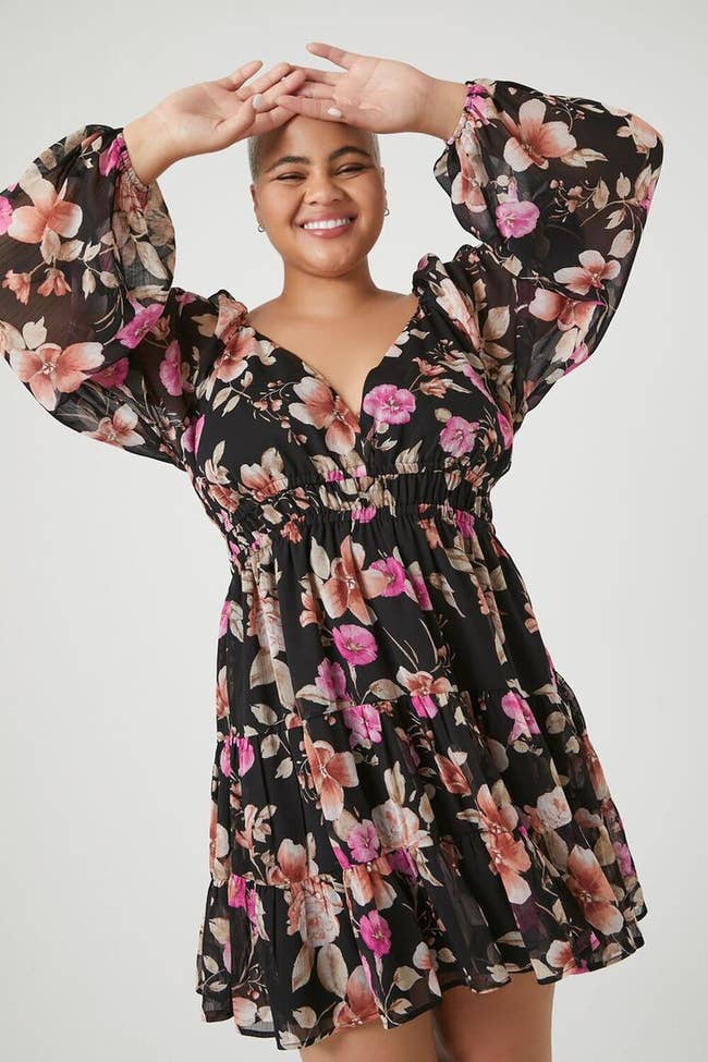 model wearing the black dress with pink flowers all over it