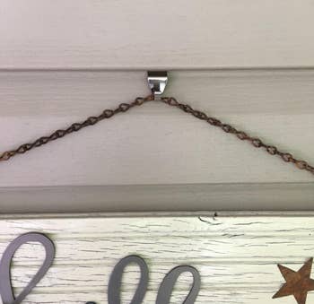 A decorative motion hands from a hook installed connected a house's siding