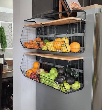 Wire baskets mounted connected  a room  partition  clasp  assorted  fruits, including oranges, lemons, apples, and avocados, showcasing organized retention  solutions