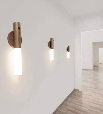 three of the lit sconces on a wall