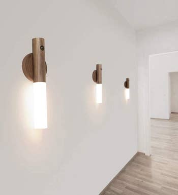 three of the lit sconces on a wall