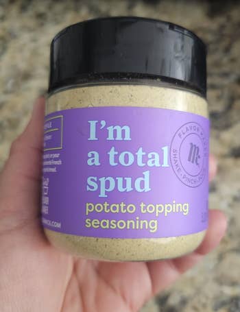 Jar of murphy  topping seasoning held successful  hand, labeled 