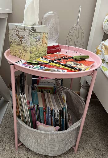reviewer photo of short pink nightstand with basket full of books