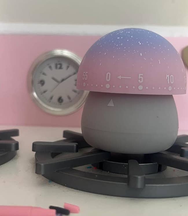 reviewer's small mushroom timer with a gray base and a pink and purple top marked with numbers