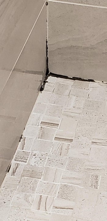 moldy corner of a bathroom floor