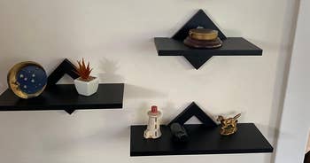 Reviewer image of products in black on a white wall with small knick-knacks on it