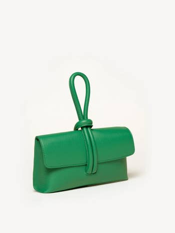 Green handbag with a distinctive loop handle design on a white background
