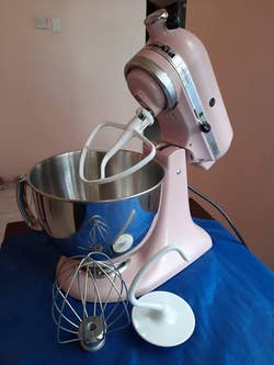 reviewer photo of the pink stand mixer and its three attachments
