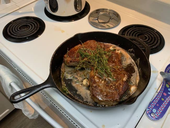 reviewer's steaks cooking in large skillet