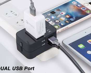 the black travel adaptor being used to charge multiple devices