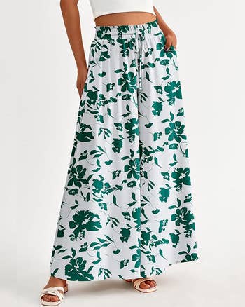 model in white and green floral wide-legged pants paired with white sandals