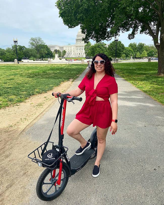 reviewer in red tie-front short sleeve romper and slip-on black sneakers