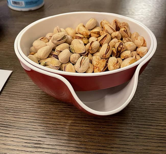 reviewer photo of the bowl holding pistachios and you can see there's a built-in tray for holding the empty shells
