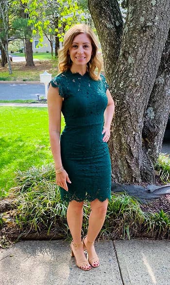 Reviewer wearing knee-length green lace dress with crew neckline with nude open toe heels outside in front of a tree