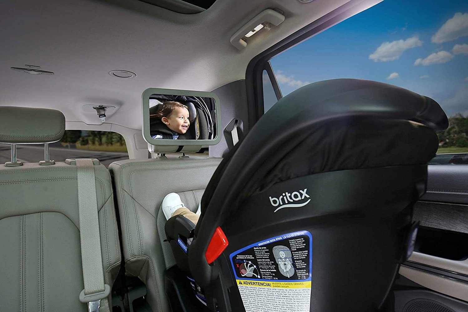 the mirror attached to a headrest with a baby looking into it