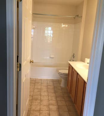 a reviewer photo of a bathroom with tan tile floors 