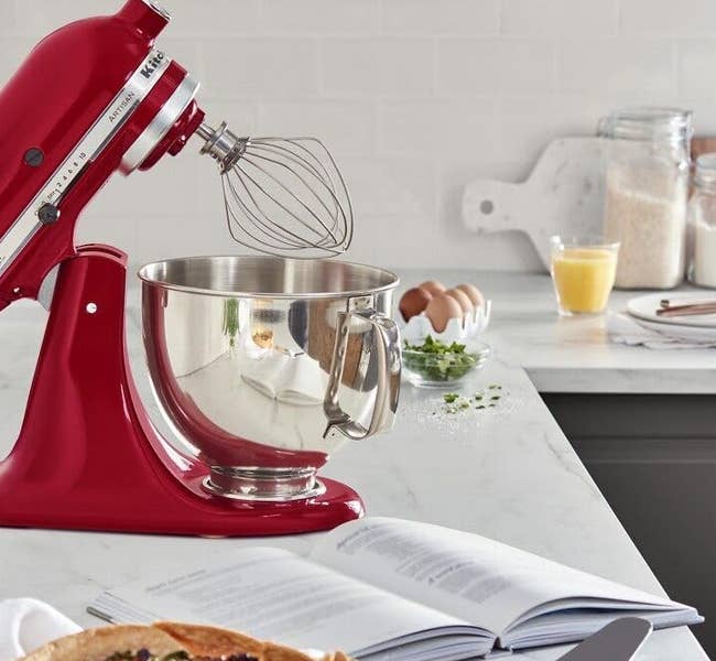 red stand mixer with bowl and whisk attachment