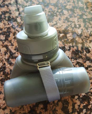 a reviewer photo of the bottle in gray rolled up to reduce the size 