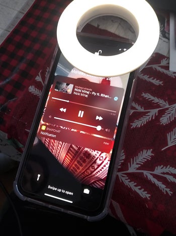 The ring light clipped to a reviewer's iPhone