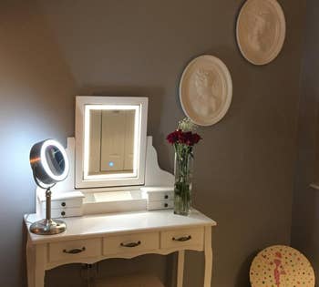 reviewer photo of the vanity in white, LED lights lit up