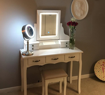 reviewer photo of the vanity in white, LED lights lit up