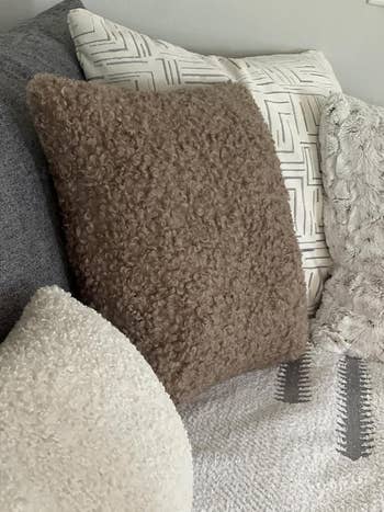 Textured propulsion  pillows successful  assorted  patterns and materials, styled connected  a sofa, showcasing cozy and fashionable location  decor options. 