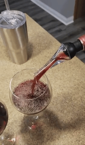 gif of another. reviewer pouring red wine into a glass using the aerator and pourer on the bottle