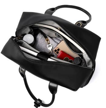 a top-down view of the open tote filled with a laptop, sweater, umbrella, and more 