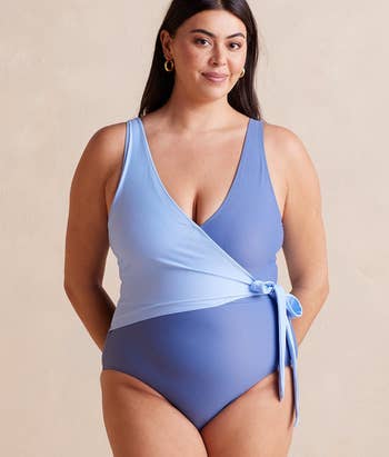 model in a blue one-piece swimsuit with a wrap tied waist detail