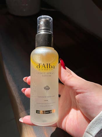 reviewer holding bottle of spray serum