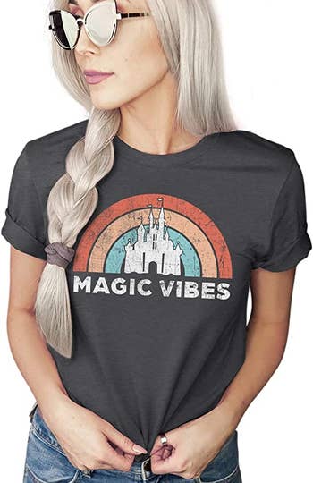 a model in a dark gray tee with a rainbow on it and the castle with 