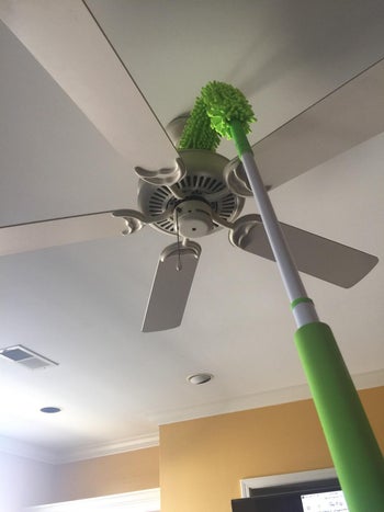 another reviewer photo of the flexible head duster cleaning the base of the ceiling light fixture