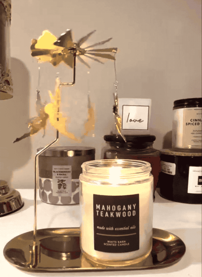 A gif of a reviewer's candle under the carousel with fairies, with the fairies spinning