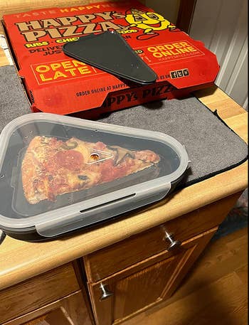 A triangular storage box with a pizza slice in it 