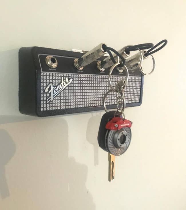 The key holder hanging on a reviewer's wall with four spots for keys