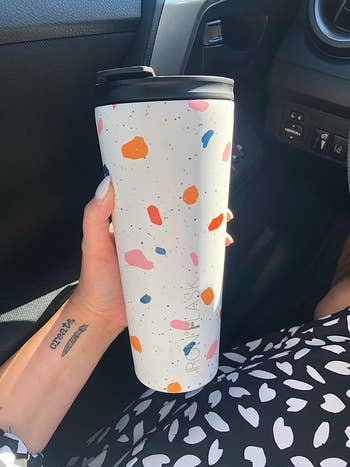 reviewer holding 20oz tumbler with colorful speckled design