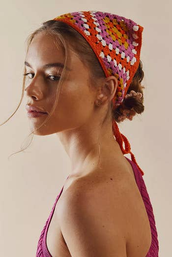 Model in a white, orange, and pink crocheted tie-string hair scarf 