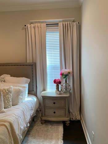 the same type of curtains hung in a bedroom over a window