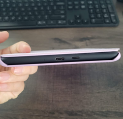 reviewer holding up the kindle sideways to show how thin it is