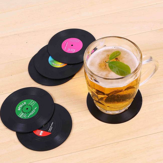 a set of coasters on a table with a drink on one of them